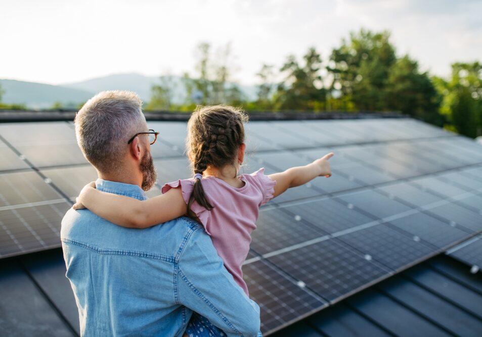 Rear,View,Of,Dad,With,Girl,On,Roof,With,Solar